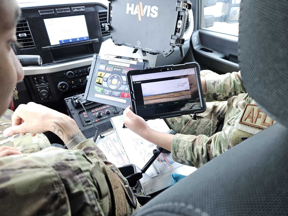 A U.S. Air Force operator running the LAIRA inspection app on a tablet inside an airfield vehicle at Wright-Patterson AFB.